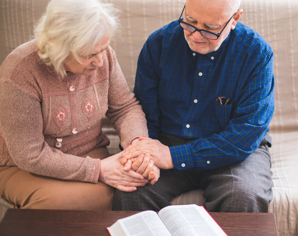 examples of what a hospice chaplain does man praying with sick woman